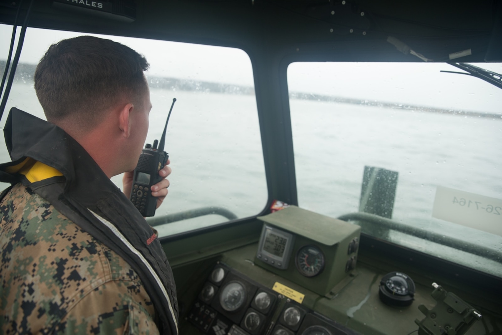 U.S. Marine Cpl. Braxton Shrader, a combat engineer with Bridge Company, 7th Engineer Support Battalion, 1st Marine Logistics Group communicates over the radio on a Bridge Erection Boat (BEB) during the boat licensing course along the coast of Camp Pendleton, Calif., June 21, 2017. The BEB deploys improved ribbon bridges, which are long two-way platforms used to transport heavy equipment, such as tanks, over bodies of water. (U.S. Marine Corps photo by Lance Cpl. Timothy Shoemaker)