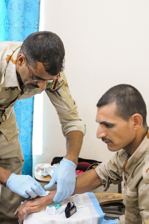 Two members of the Iraqi security forces practice correctly inserting an IV during the Iraqi Flight Medic Course at Camp Taji, Iraq, June 6, 2017. The course covered basic casualty care and additional flight-focused instruction in altitude physiology and aircraft safety. This training is part of the overall Combined Joint Task Force – Operation Inherent Resolve building partner capacity mission by training and improving the capability of partnered forces fighting ISIS. CJTF-OIR is the global Coalition to defeat ISIS in Iraq and Syria. (U.S. Army photo by Capt. Stephen James)