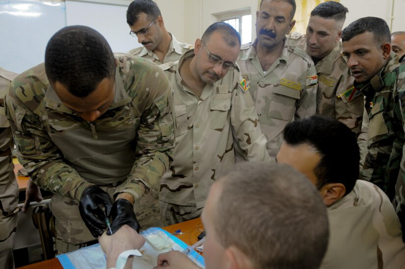 Spc. James Nowell (left), a medic with the 29th Combat Aviation Brigade, demonstrates the proper technique of inserting an IV on Sgt. Michael Sweeney, a medic with the 82nd Airborne Division, to Iraqi security forces soldiers during the instructional phase of the Iraqi Flight Medic Course at Camp Taji, Iraq, June 6, 2017. The course covered basic casualty care and additional flight-focused instruction in altitude physiology and aircraft safety. This training is part of the overall Combined Joint Task Force – Operation Inherent Resolve building partner capacity mission by training and improving the capability of partnered forces fighting ISIS. CJTF-OIR is the global Coalition to defeat ISIS in Iraq and Syria. (U.S. Army photo by Capt. Stephen James)