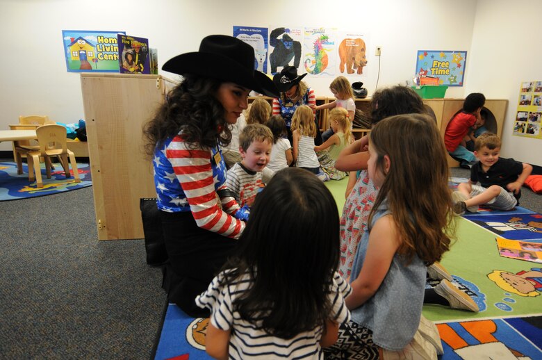 Sierra Silva, Aide to Girl of the West, plays and speaks with children from the Child Development Center during a visit at Schriever Air Force Base, Colorado, Thursday, June 22, 2017. The Girls of the West made appearances all over the Pikes Peak region to promote the 77th Pikes Peak or Bust Rodeo. (U.S. Air Force photo/James L. Hodges)