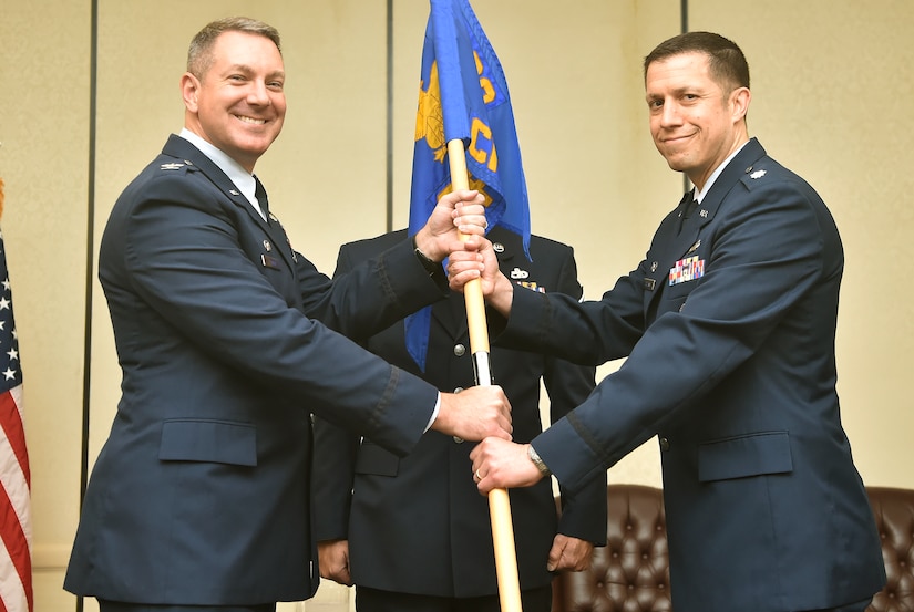 Col. Rob Lyman, left, 628th Air Base Wing commander, passes the guideon to Lt. Col. Bryan Collins, right, 628th Comptroller Squadron incoming commander, during the 628th CPTS change of command ceremony at Joint Base Charleston, S.C., June 28. The squadron bid farewell to the outgoing commander Lt. Col. Samual Shimp and welcomed Collins as the new squadron commander.