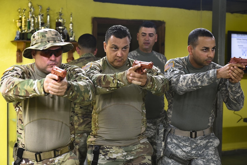 A team from Joint Task Force-Bravo's Joint Security Forces show local police forces how to group before entering a room for clearing at La Paz, Honduras so they can communicate with gestures and body movements when entering a room for clearing during a 