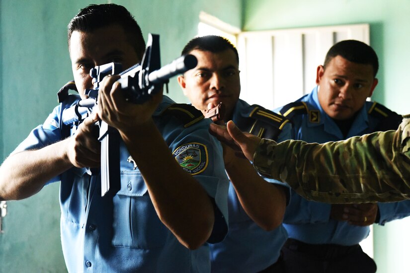 Honduran police forces prepare to enter a room for clearing under a hostile scenario during a Subject Matter Expert Exchange with Joint Security Forces from Joint Task Force-Bravo at La Paz, June 20, 2017.  The Military Police members shared knowledge on how to enter buildings and clear the areas tactically, providing the Honduran forces with necessary techniques and procedures that can help prevent casualties among their force while entering hostile situations.  