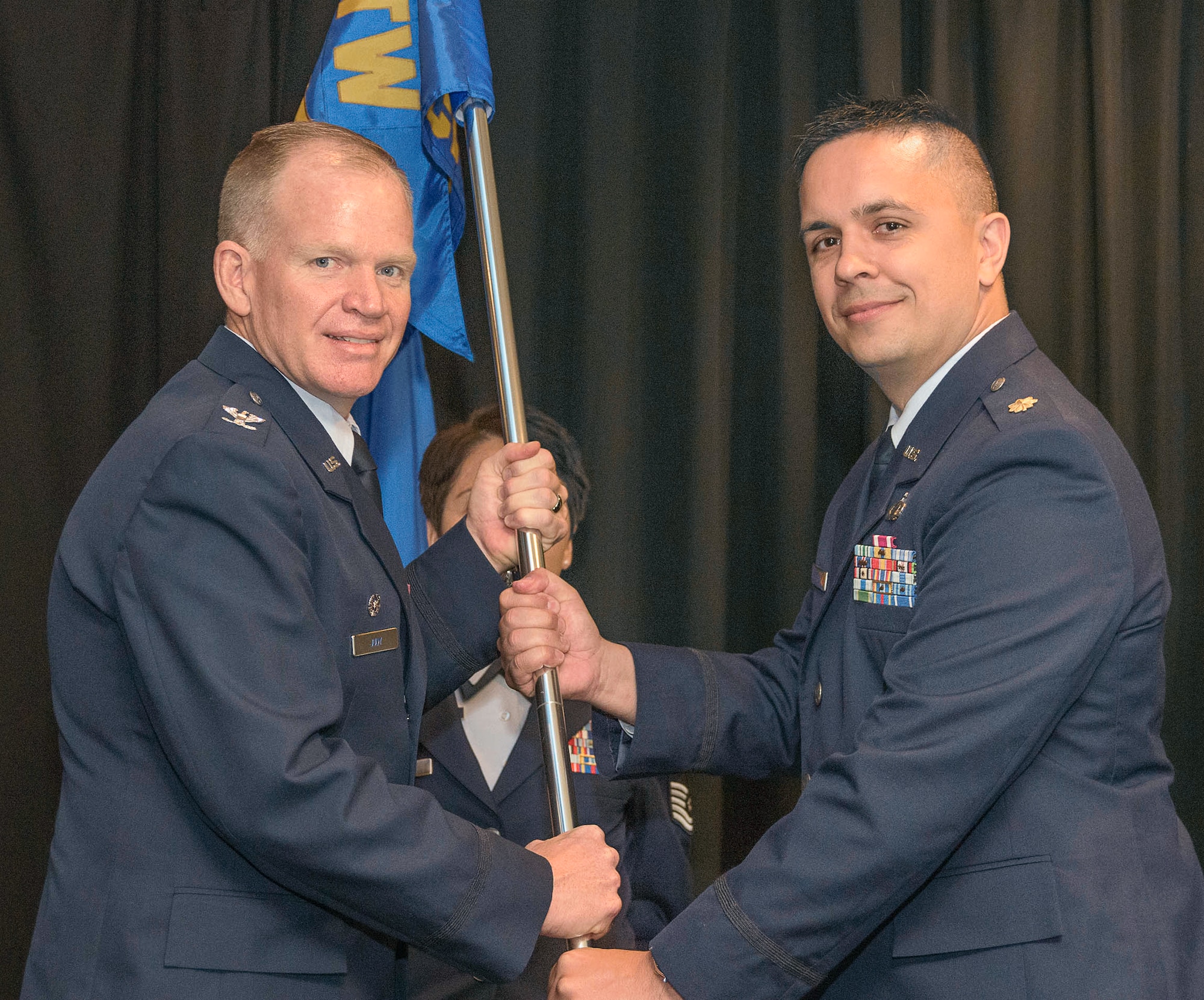 Maj. Steven Peterson, right, accepts the guidon and command of the 71st Comptroller Squadron from Col. Darrell Judy, 71st Flying Training Wing commander, during a change-of-command ceremony held June 16 in the Vance Club at Vance Air Force Base, Oklahoma. (U.S. Air Force photo/ Terry Wasson)