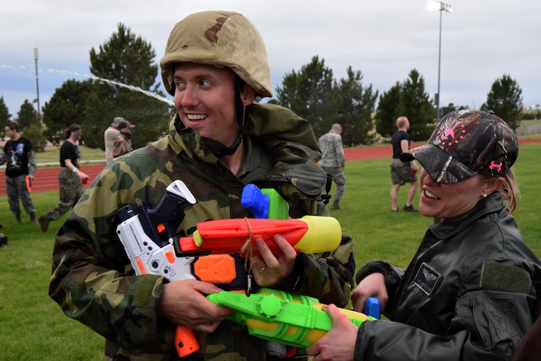 Second Lieutenant Kenneth Angel, 50th Contracting Squadron, hands out the enemy weapons capture from a water gun fight at the 50th Space Wing’s combat dining out at Schriever Air Force Base, Colorado, Friday, June 23, 2017. Water gun fights occurred sporadically during organized competitions.  (U.S. Air Force photo/Airman 1st Class William Tracy)