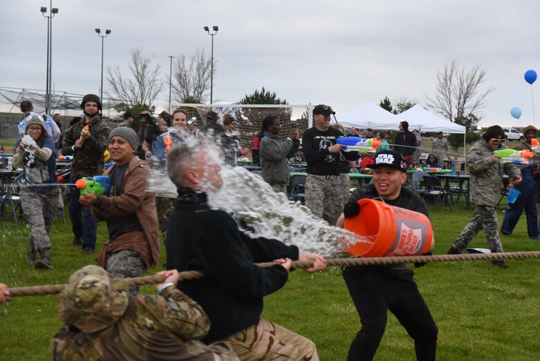 Airman 1st Class Michael Gibson, 50th Force Support Squadron, propels water at Col. Scott Angerman, 50th Network Operations Group commander, during a tug-of-war competition during the 50th Space Wing’s combat dining out at Schriever Air Force Base, Colorado, Friday, June 23, 2017. Those not involved in competition played a role distracting and disrupting throughout organized competitions (U.S. Air Force photo/Airman 1st Class William Tracy)