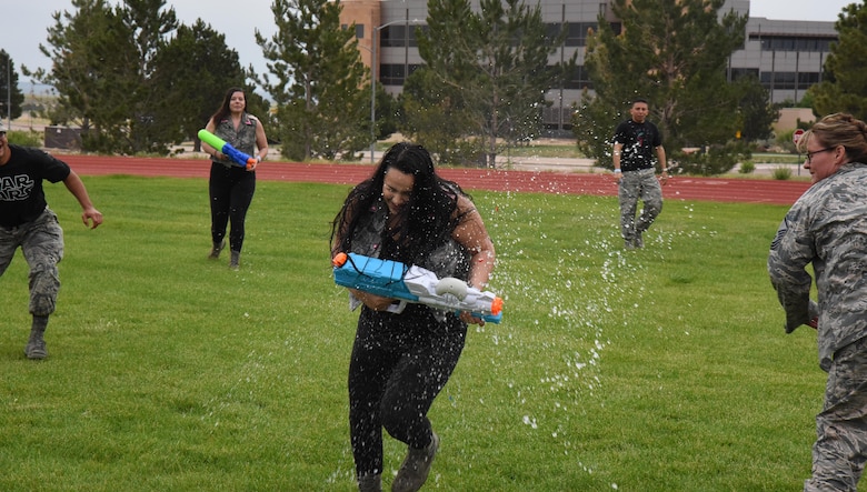 Airman 1st Class Michelle Hudson, 50th Force Support Squadron falls victum to a barrage of water balloons during the 50th Space Wing’s combat dining out at Schriever Air Force Base, Colorado, Friday, June 23, 2017. Participants employed a variety of water-based weapons against rivals from other squadrons during the event. (U.S. Air Force photo/Airman 1st Class William Tracy)