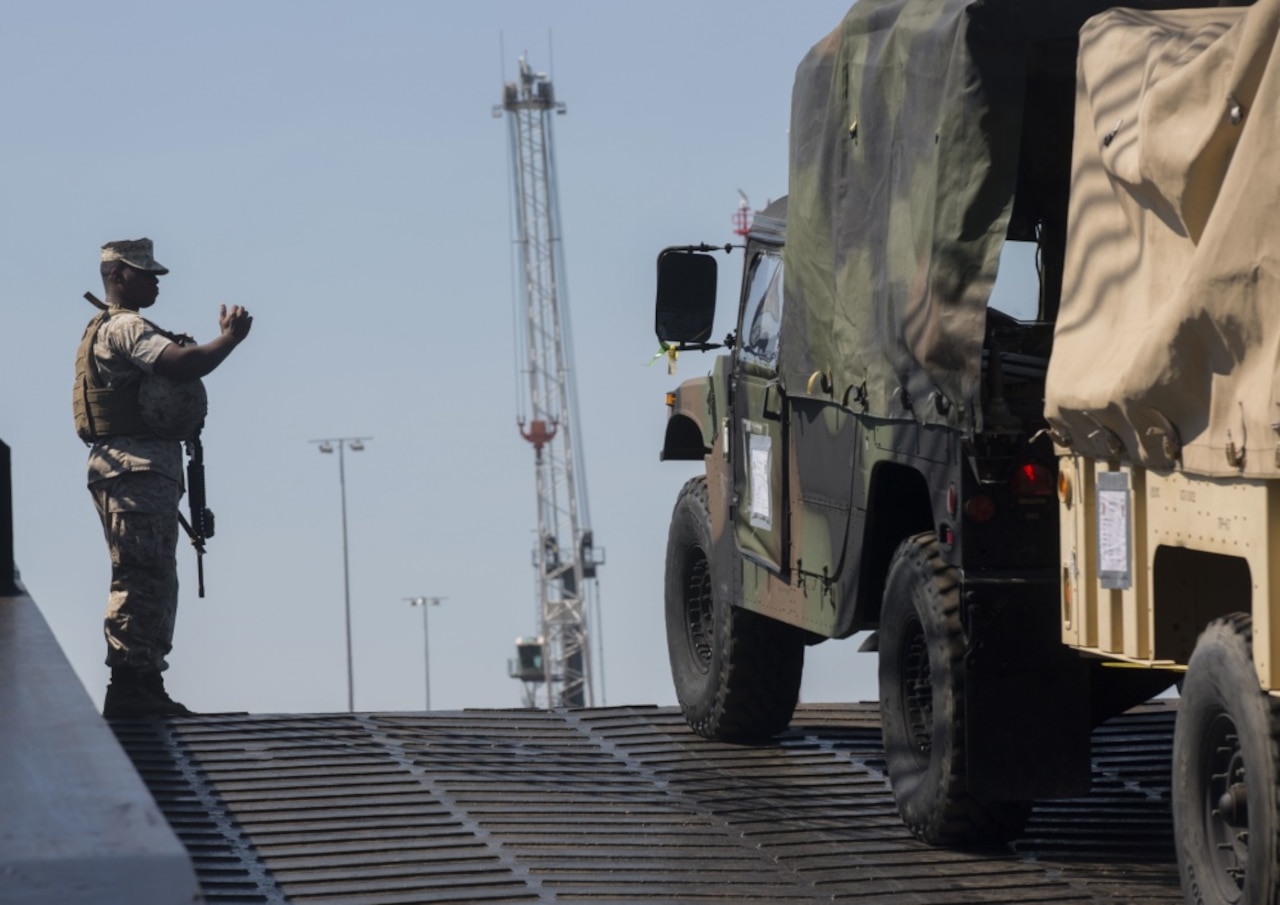 A Marine with Headquarters, 4th Marine Regiment, 1st Marine Division, directs a Humvee off the USNS 2nd Lt. John P. Bobo in Darwin, Australia, June 15, 2017. The Marines and sailors brought 39 tactical vehicles to enhance their capabilities during Exercise Talisman Saber. Marine Corps photo by Lance Cpl. Damion Hatch Jr.