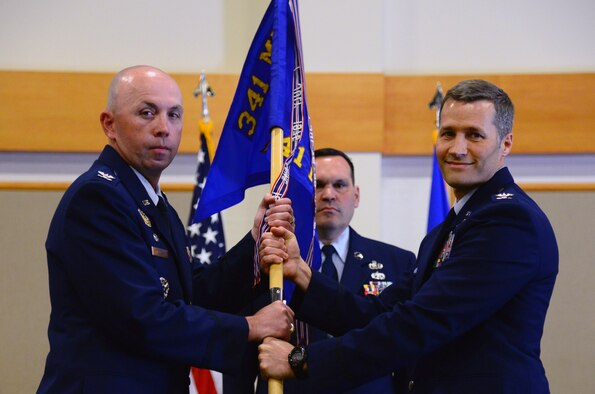 Col. Marcus Glenn, right, accepts command of the 341st Mission Support Group from Col. Ron Allen, 341st Missile Wing commander, June 28, at Malmstrom Air Force Base, Mont. Chief Master Sgt. Michael Frank, 341st MSG chief, looks on. (U.S. Air Force photo/Senior Airman Magen M. Reeves)