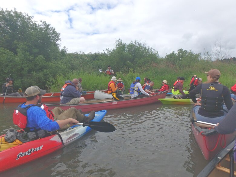 Cameron Bishop, Willamette Valley Project natural resource specialist (center, on-shore), talks to a group about the Long Tom River in the Willamette Valley, June 13. Bishop conducted the second of these trips to bring attention to the difficulties of managing this channel.