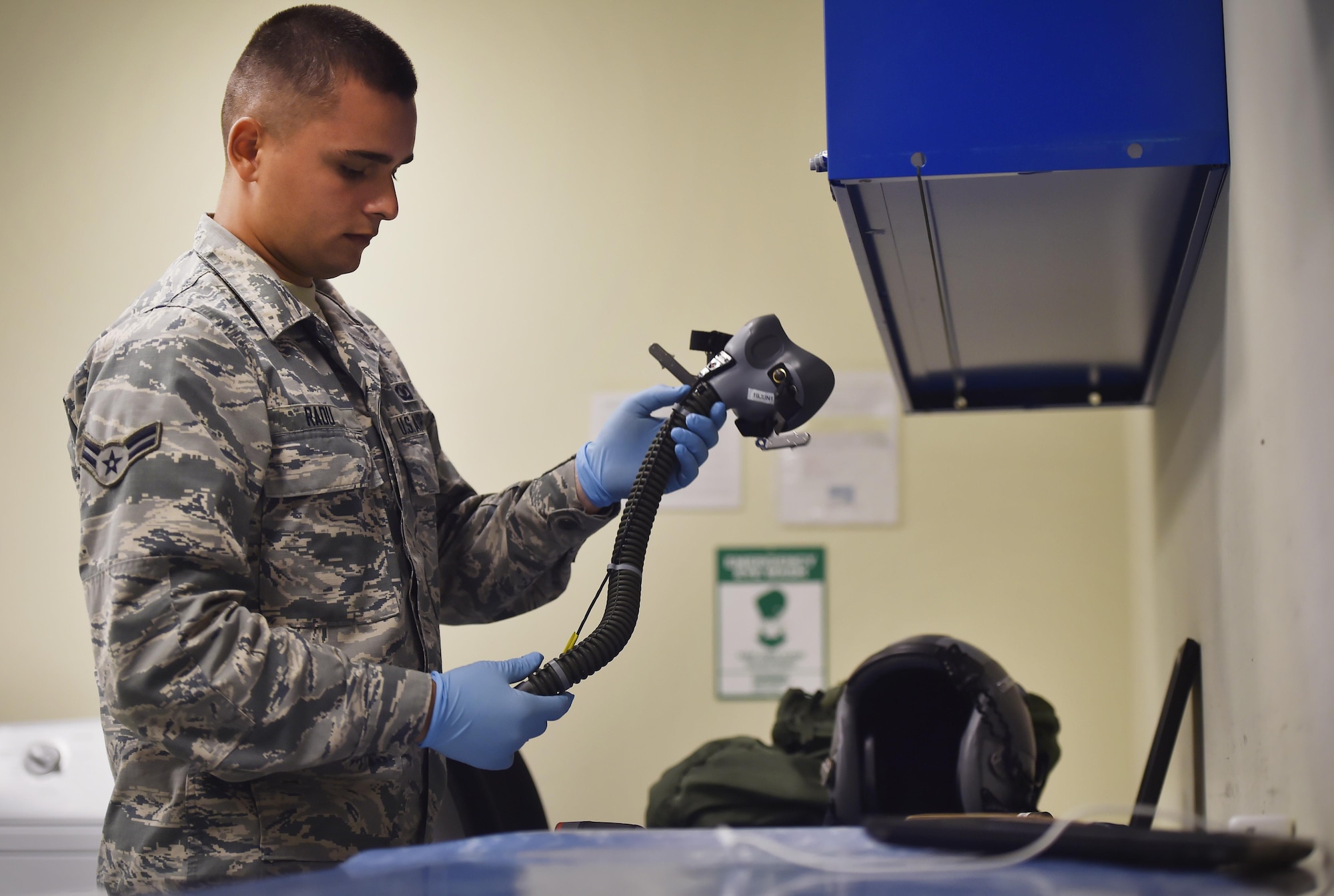 Airman 1st Class Ion Radu, 437th Operation Support Squadron aircrew flight equipment, inspects a helmet and oxygen mask at Joint Base Charleston, S.C., June 20. Airmen assigned to the 437th OSS AFE flight ensure that aircrew equipment including helmets, oxygen masks, life rafts, and parachutes are safe and ready for aircrew members to operate. (Photo by Staff Sgt. Christopher Hubenthal)