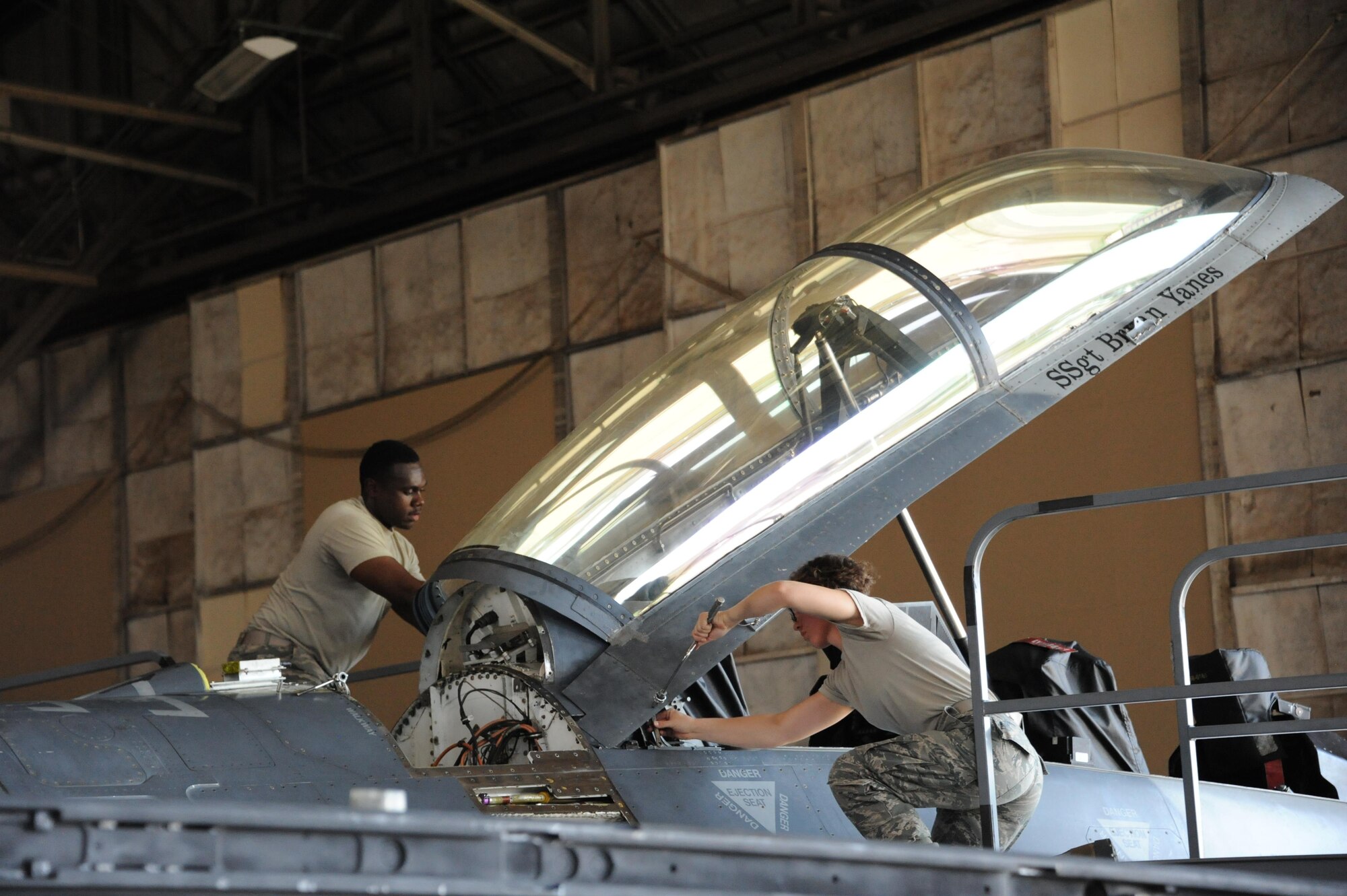 Airman 1st Class Diamond Balock White and Airman 1st Class Raena Sadowski, 56th Component Maintenance Squadron aircrew egress technicians, prepare an F-16 Fighting Falcon canopy for removal on June 26, 2017 at Luke Air Force Base, Ariz. Canopy removal on fighter jets is part of routine maintenance to ensure proper safety for pilots. (U.S. Air Force photo by Airman 1st Class Caleb Worpel)
