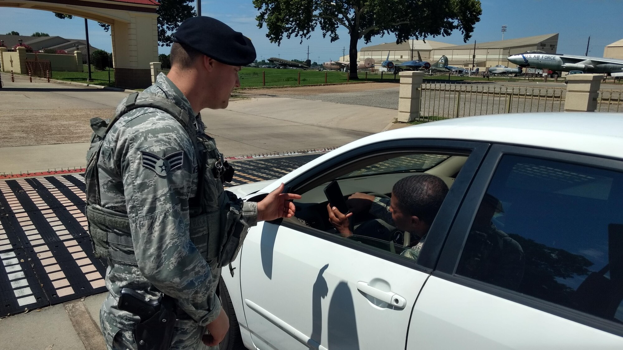 An Airman with the 2nd Security Forces Squadron speaks to a motorist at Barksdale Air Force Base, La., June 16, 2017. While smartphones have introduced a huge amount of convenience into our day-to-day routines, they have also introduced a new world of dangers being considered a major distraction for drivers. (U.S. Air Force Photo/ Nevardo Cayemitte)