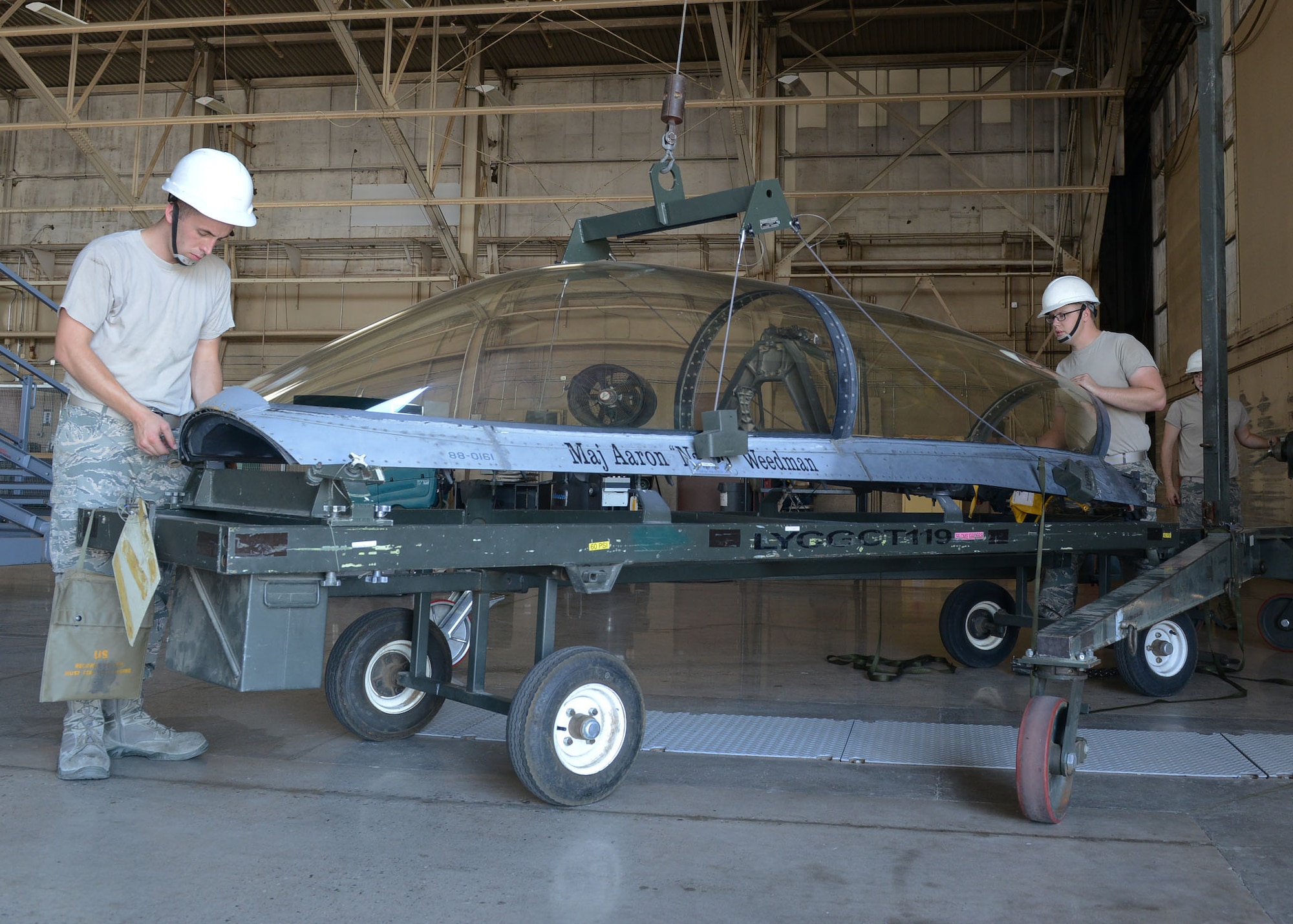 Staff Sgt. Trevor Stark, 56th Component Maintenance Squadron Aircrew egress NCO in charge, and Airman 1st Class Zeb Chadwick, 56th CMS aircrew egress technician, secure a canopy after removing it from an F-16 Fighting Falcon for routine maintenance June 26, 2017, at Luke Air Force Base, Ariz. Egress Airmen perform maintenance on ejection seats and canopies for both the F-16 and F-35 Lightning II. (U.S. Air Force photo by Senior Airman James Hensley)