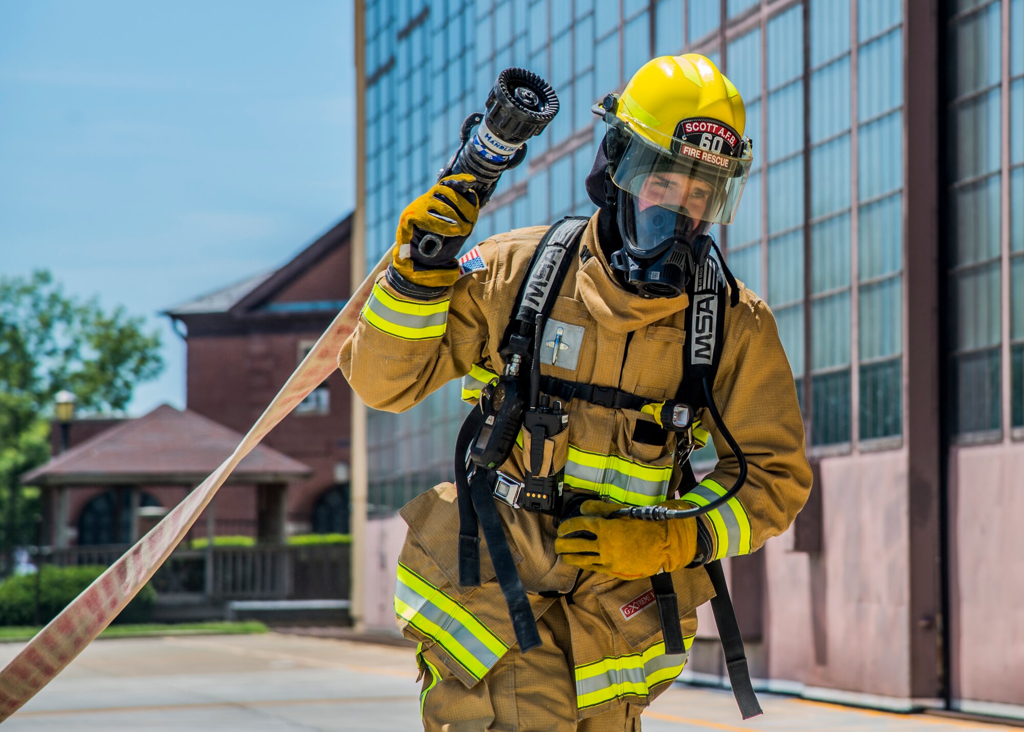Airman 1st Class Jacob Childs, 375th Civil Engineer Squadron fire fighter, performs a hose drag during a training exercise at Scott Air Force Base, Ill. on June 22, 2017. The exercise was part of the unit's Airport Rescue and Fire Fighting's training which tests their ability to arrive on scene, fight fires, and provide a rescue path as well as recover or rescue personnel. (U.S. Air Force photo by Airman 1st Class Daniel Garcia)
