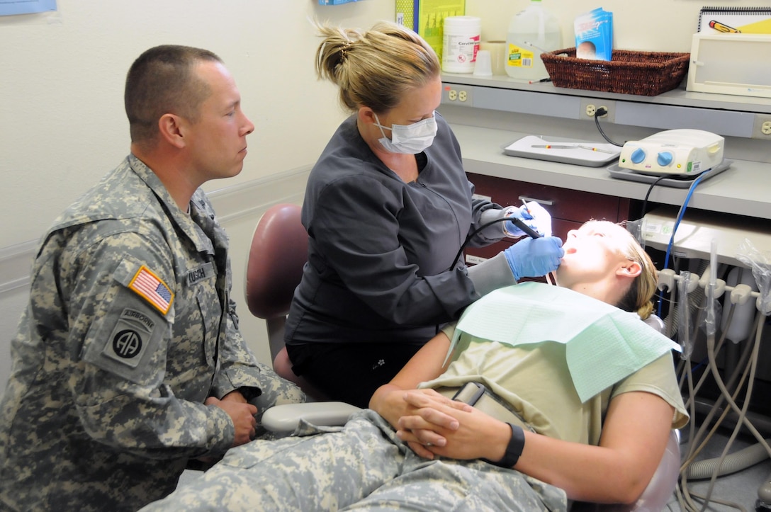 Sgt. Matthew Kunsch, a dental specialist assigned to 7406th Troop Medical Clinic located in Kansas City, Missouri, learns how to perform a general cleaning from staff member Michelle Scott, a dental hygienist on the team.  Kunsch is one of approximately 25 U.S. Army Reserve Soldiers who are working in partnership with Rosebud Indian Health Service to provide medical care to the local tribal population. 