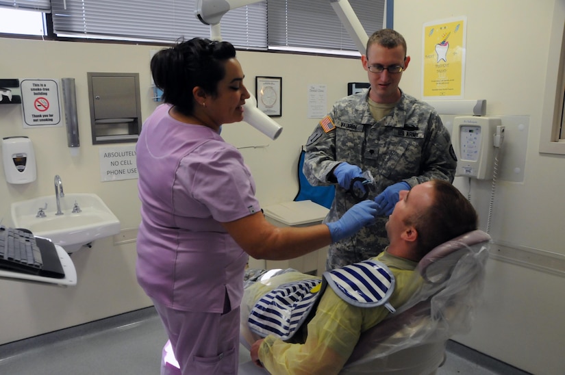 Spc. Andrew Vaughn, a dental assistant assigned to 7246th Medical Support Unit located in Elkhorn, Nebraska, learns how to take dental x-rays from staff member Mari Pasman, a dental assistant on the team.  Vaughn is one of approximately 25 U.S. Army Reserve Soldiers who are working in partnership with Rosebud Indian Health Service to provide medical care to the local tribal population. 