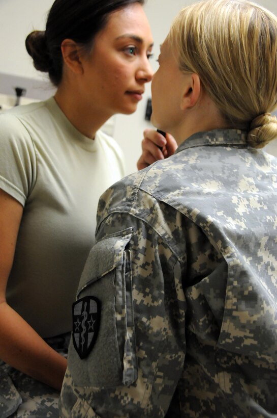 Capt. Lindee Abe, a family nurse practitioner assigned to 7246th Medical Support Unit located in Elkhorn, Nebraska, examines the eyes of a fellow Soldier in the unit.  Abe is one of approximately 25 U.S. Army Reserve Soldiers who are working in partnership with Rosebud Indian Health Service to provide medical care to the local tribal population. 