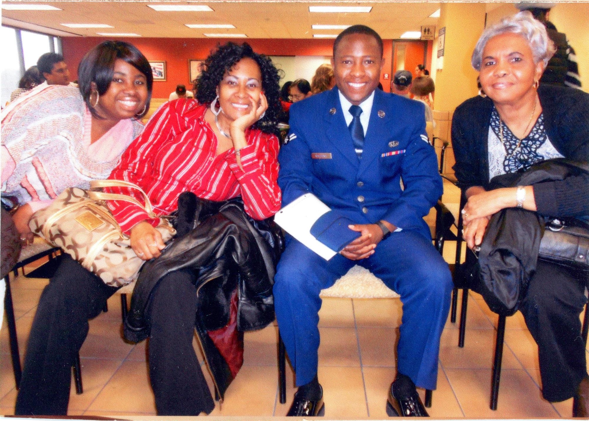 Then U.S. Air Force Airman 1st Class Tinashe Machona, assigned to the 116th Air Control Wing, poses for a photograph with co-workers anticipating his Oath of Allegiance, during a citizenship ceremony in Atlanta, Ga., Jan. 12, 2012. Machona worked as an administrative assistant at a real estate law firm in Tucker, Ga. (Courtesy photo, 2nd Lt. Tinashe Machona)