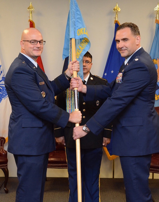 Air Force Lt. Col. James Malec, right, assumes command of Defense Logistics Agency at Oklahoma City from Air Force Col. Kenton Ruthardt. Former DLA Aviation Commander Air Force Brig. Gen. Allan Day, left, officiated the ceremony held at the Tinker Aerospace Complex, Tinker Air Force Base, Oklahoma, June 23, 2017.