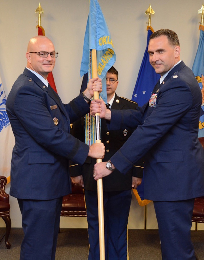 Air Force Lt. Col. James Malec, right, assumes command of Defense Logistics Agency at Oklahoma City from Air Force Col. Kenton Ruthardt. Former DLA Aviation Commander Air Force Brig. Gen. Allan Day, left, officiated the ceremony held at the Tinker Aerospace Complex, Tinker Air Force Base, Oklahoma, June 23, 2017.