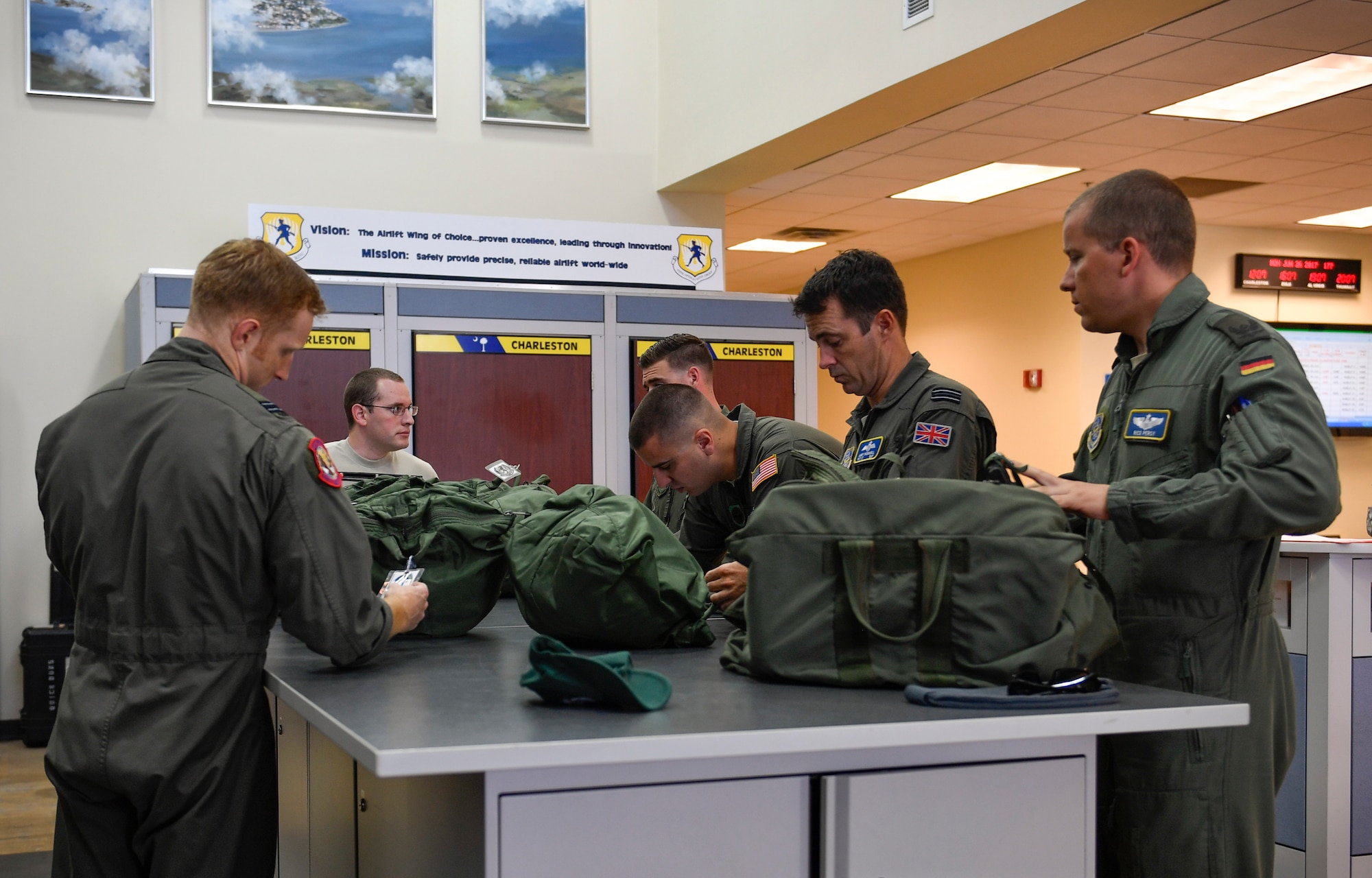 Pilots participating in the foreign exchange program and aircrew members from the 14th Airlift Squadron, inspect flight operational equipment prior to a mission flight here June 26, 2017. The focus of the program is cross-training and cross-operation aspects that provide insight for foreign nationals learning U.S. Air Force procedures and to provide additional understanding of the different ways our partner nations operate.
