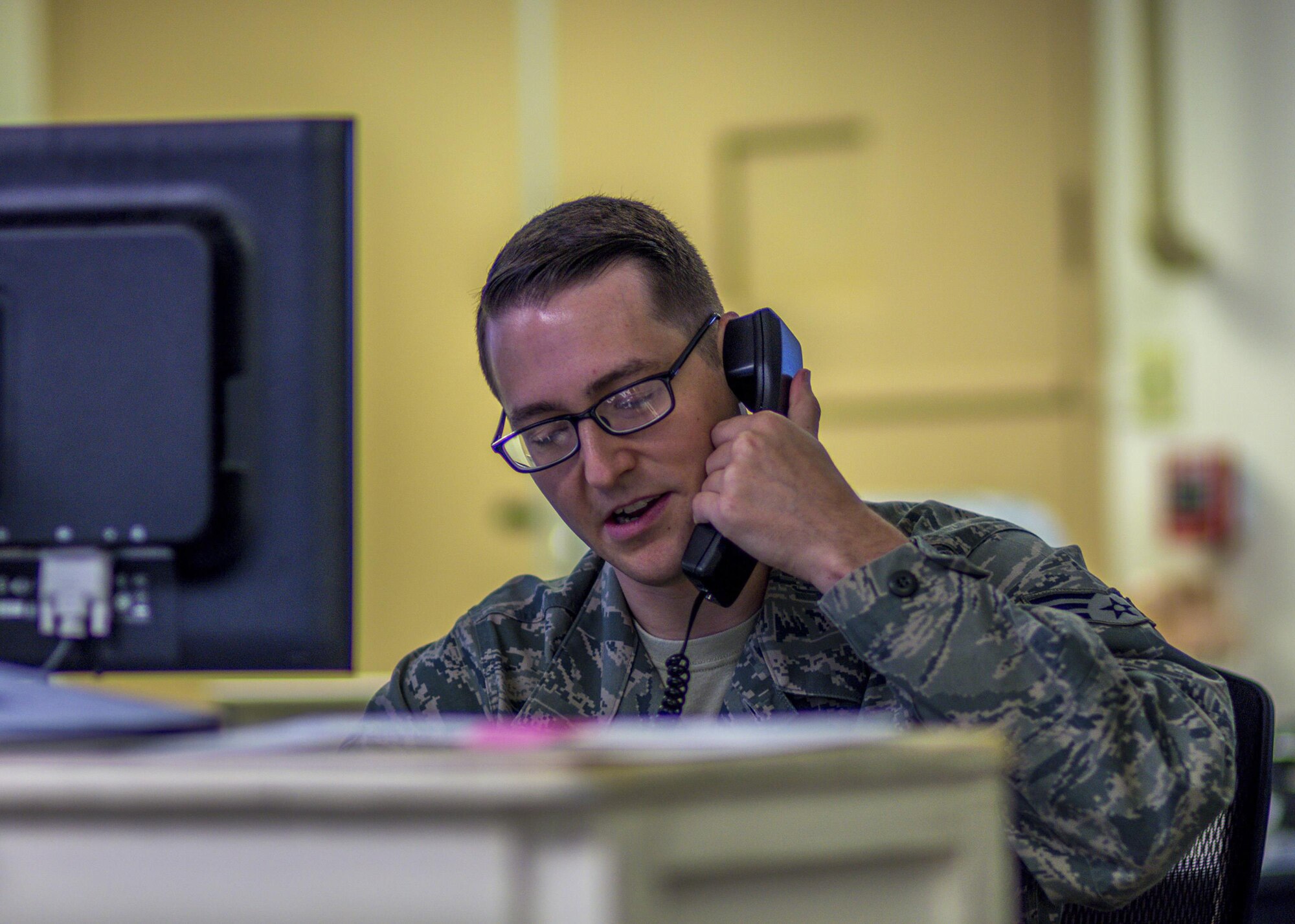 Senior Airman David Ruesche, 20th Space Control Squadron weapons and tactics instructor, calls to report shots fired on the second floor of the building during active shooter training at site C-6 Eglin Air Force Base, Fla., June 27. Walton County Sheriff's Office deputies and first responders from Eglin participated in the joint exercise to improve local active shooter processes, communication, and response coordination. (U.S. Air Force photo/Kristin Stewart)