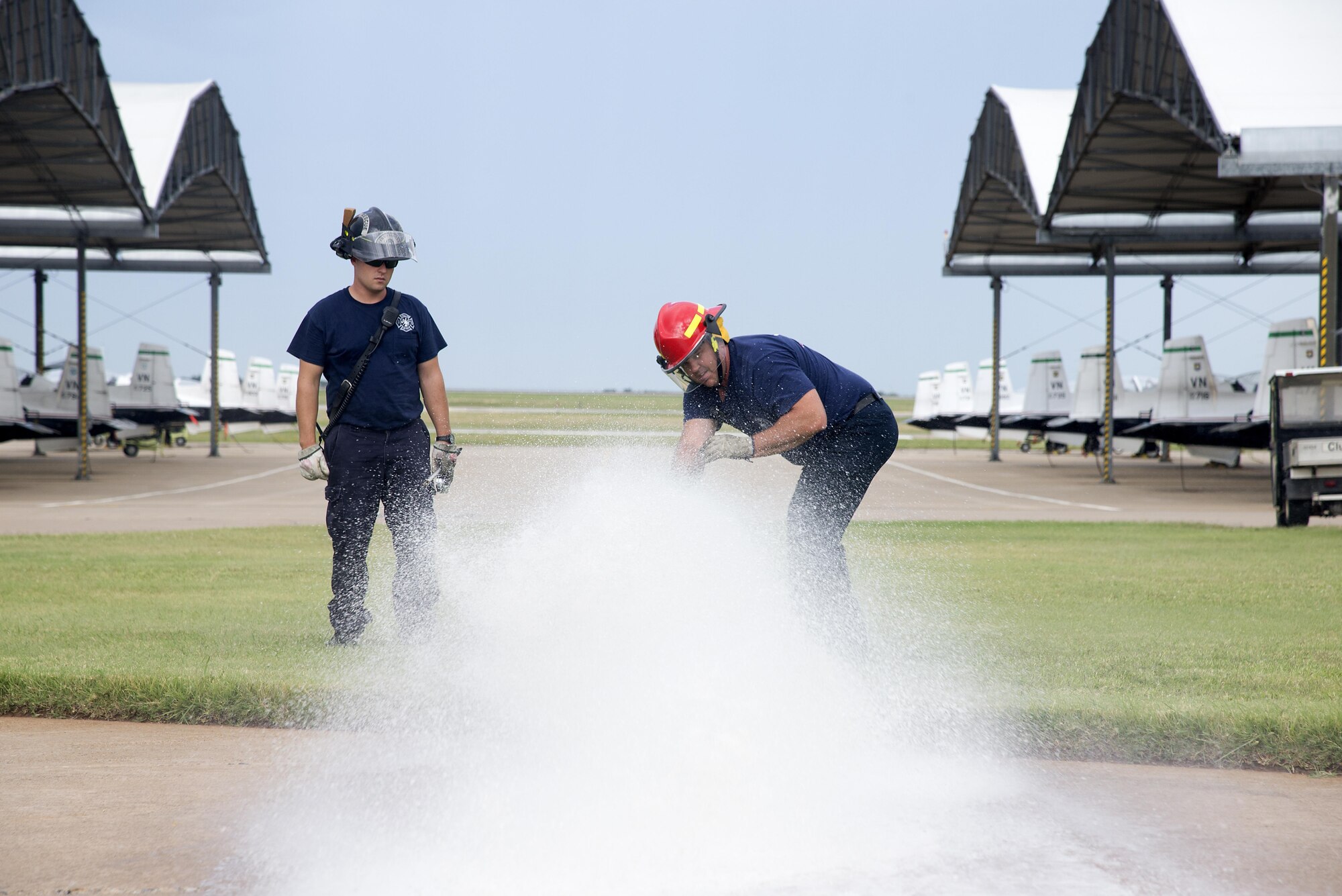Base firefighters Mason Hornberger, left, and Wes Felber open up a fire hydrant on the flightline June 24. This is part of an annual test to make sure the installation fire hydrants are meeting National Fire Protection Association's requirements. (U.S. Air Force photo/ Airman 1st Class Taylor Crul) 
