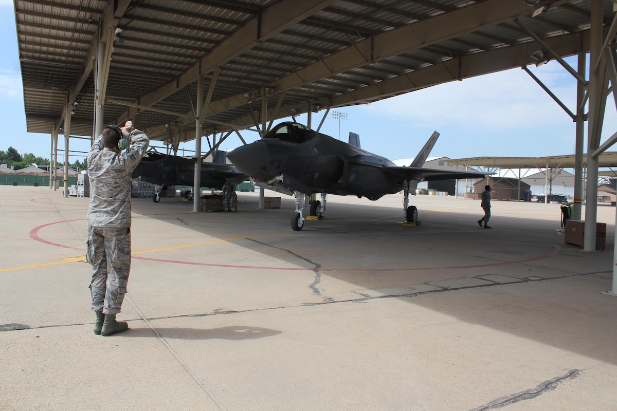 Airman 1st Class Matthew Clark with the 34th Aircraft Maintenance Unit directs the pilot who flew the 388th Fighter Wing’s 24th aircraft assigned to the 34th Fighter Squadron / 34th AMU June 21. The 24th aircraft is significant because it completes the first full F-35A squadron at an operational unit. (U.S. Air Force photo/Donovan K Potter)