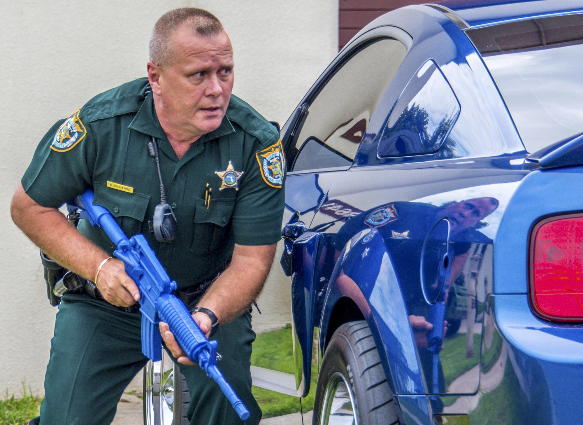 Deputy Ross Richards, Walton County Sheriff’s Office, sweeps the entrance of the building in response to a report of shots fired at the 20th Space Control Squadron during active shooter training at site C-6 Eglin Air Force Base, Fla., June 27. Walton County deputies and first responders from Eglin participated in the joint exercise in which a person on the second floor fired their weapon. The purpose of the joint exercise to improve local active shooter processes, communication, and response coordination. (U.S. Air Force photo/Kristin Stewart)