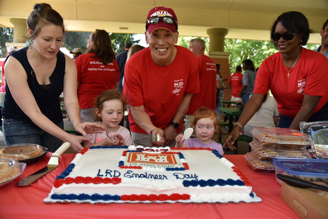 Brig. Gen. Toy cuts the cake with the two youngest LRD members at the 2017 LRD Engineer Day Picnic at Lunken Airfield in Cincinnati, Ohio.