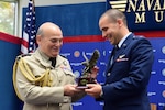 Air Chief Marshal Stuart Peach, Chief of the Defence Staff of the United Kingdom presents the Air Education Training Command Commander’s Trophy for Combat Systems Officer Class 17-11 to 2nd Lt. Logan Pietrzak during the graduation ceremony held inside the Naval Aviation Museum, Naval Air Station Pensacola, Florida., June 23, 2017.