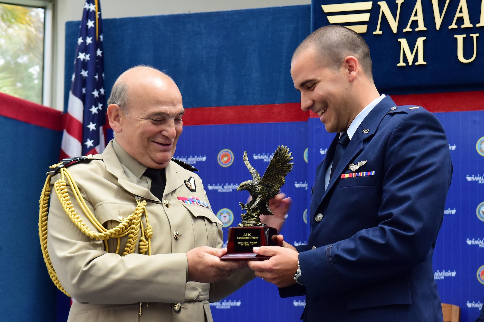 Air Chief Marshal Stuart Peach, Chief of the Defence Staff of the United Kingdom presents the Air Education Training Command Commander’s Trophy for Combat Systems Officer Class 17-11 to 2nd Lt. Logan Pietrzak during the graduation ceremony held inside the Naval Aviation Museum, Naval Air Station Pensacola, Florida., June 23, 2017.