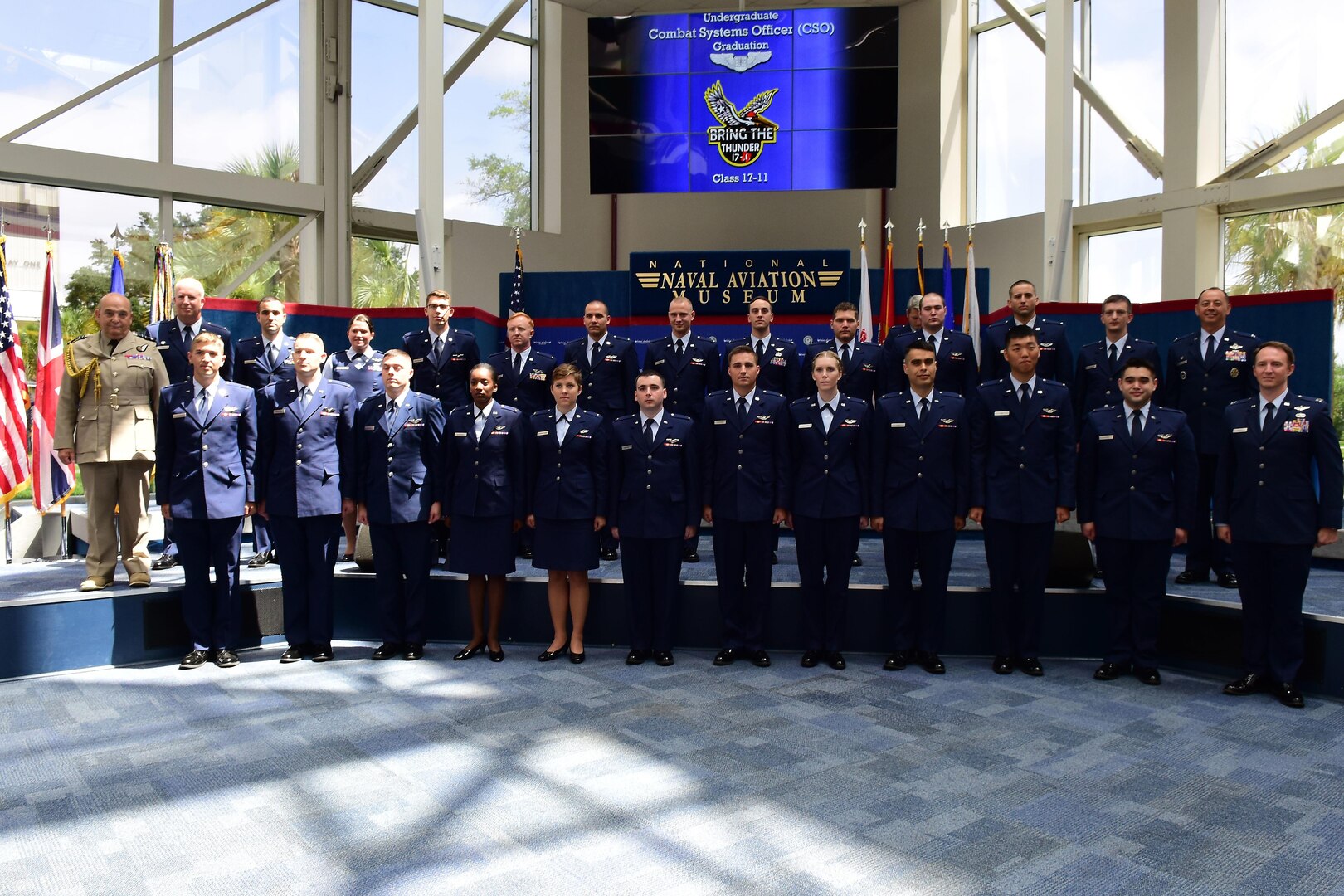 Air Chief Marshal Stuart Peach, Chief of the Defence Staff of the United Kingdom, Col. Joel Carey, 12th Flying Training Wing commander, Col. John Edwards, 479th Flying Training Group commander and Combat Systems Officer Class 17-11 pose for a group photo inside the Naval Aviation Museum, Naval Air Station Pensacola, Florida, June 23, 2017.