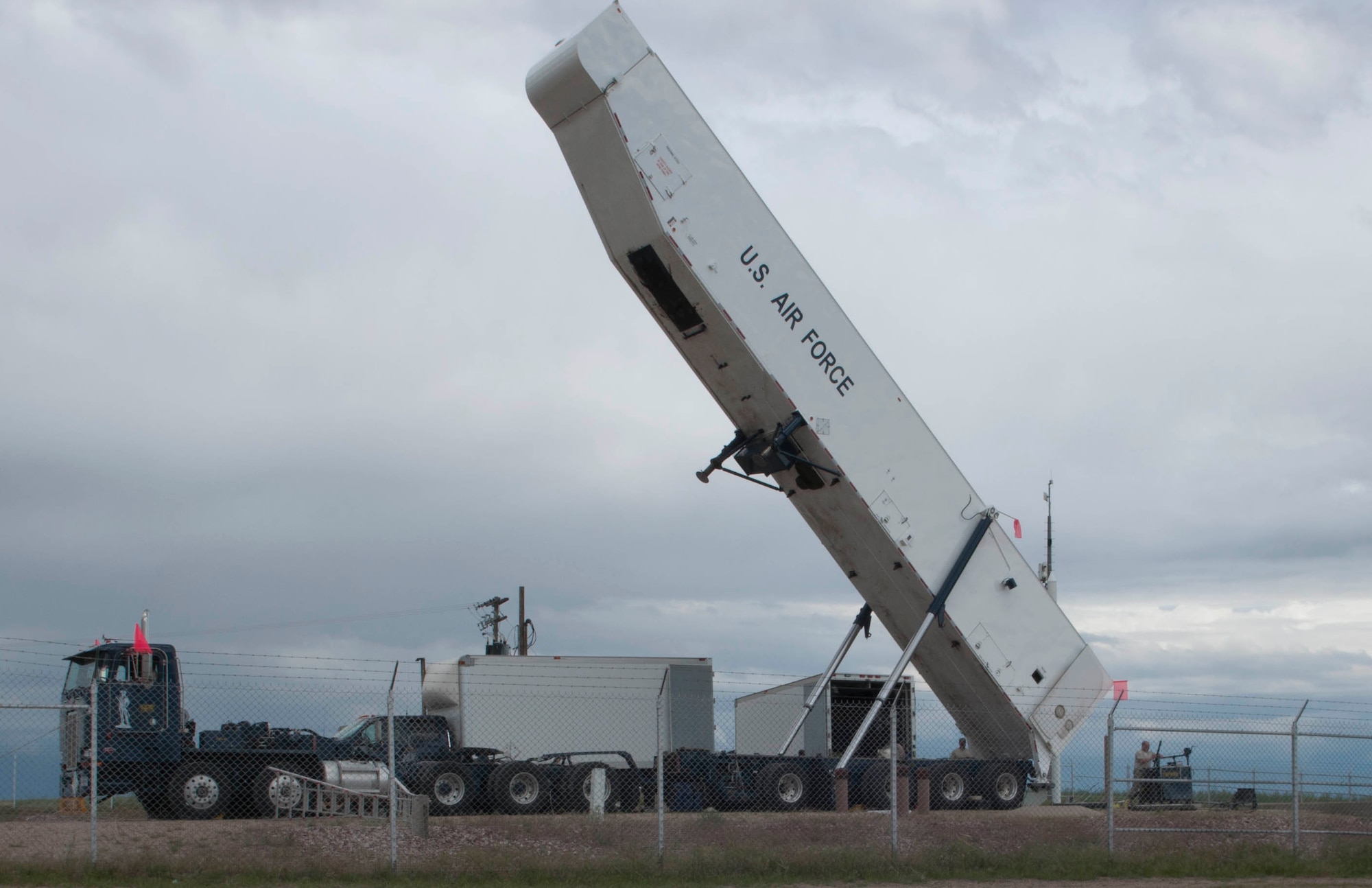 A transporter erector attached to a payload transporter is raised in the 90th Missile Wing missile complex, June 6, 2017. The TE was stood up to prepare for the removal of a missile from the ground. The missile was removed to comply with the New START Treaty agreement with Russia. The Air Force met their NST requirements when the 50th Minuteman III Intercontinental Ballistic Missile was removed from a silo in the 90th MW missile complex. (U.S. Air Force photo by Airman 1st Class Breanna Carter)