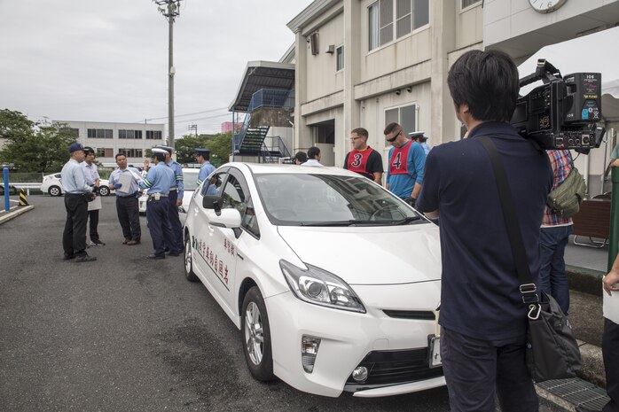 Local Japanese media record video during a free driving class held for Marine Corps Air Station Iwakuni residents in Iwakuni City, Japan, June 28, 2017. The event was the first of its kind held in Iwakuni City. Twenty station residents were invited to take part in the short educational workshop aimed to decrease the number of traffic accidents and violations caused by station residents. (U.S. Marine Corps photo by Lance Cpl. Carlos Jimenez)