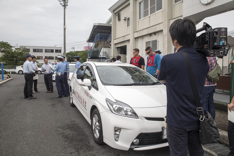 Local Japanese media record video during a free driving class held for Marine Corps Air Station Iwakuni residents in Iwakuni City, Japan, June 28, 2017. The event was the first of its kind held in Iwakuni City. Twenty station residents were invited to take part in the short educational workshop aimed to decrease the number of traffic accidents and violations caused by station residents. (U.S. Marine Corps photo by Lance Cpl. Carlos Jimenez)