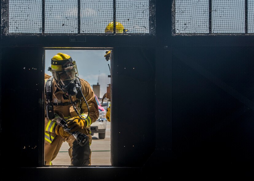 Members of the 375th Civil Engineer Squadron fire fighters perform an exercise at Scott Air Force Base, Ill. on June 22, 2017. The exercise was part of the unit's Airport Rescue and Fire Fighting's training which tests their ability to arrive on scene, fight fires, and provide a rescue path as well as recover or rescue personnel. (U.S. Air Force photo by Airman 1st Class Daniel Garcia)