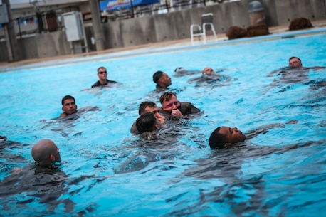 U.S. Marines with Alpha Company, 1st Battalion, 3rd Marine Regiment, inflate their uniform as a flotation device during annual swim qualification aboard Camp Hansen, Okinawa, Japan, June 25, 2017. The Marines completed their swim qualification to build confidence and increase survivability in the water. The Hawaii-based battalion is forward deployed to Okinawa, Japan as part of the Unit Deployment Program. (U.S. Marine Corps photo by Cpl. Aaron S. Patterson/Released)