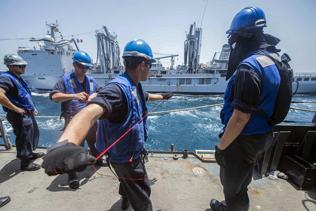 Navy Seaman Dowson Roth heaves a messenger line aboard the USS Vella Gulf from the French navy replenishment tanker FS Var during an underway replenishment near Bahrain, June 19, 2017. The Vella Gulf was participating in Exercise Spartan Kopis. Navy photo by Petty Officer 2nd Class Austin L. Simmons