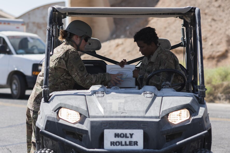 Tech. Sgt. Nikki Webb, 332nd Air Expeditionary Wing Airmen ministry center non-commissioned officer in charge, left, and Chaplain (Capt.) Xiomara Diaz, 332nd AEW, removes freeze pops from their cooler June 2, 2017, in Southwest Asia. On Fridays the religious support team delivers more than 100 freeze pops to Airmen throughout the installation to boost morale and help them stay cool. (U.S. Air Force photo/Senior Airman Damon Kasberg)