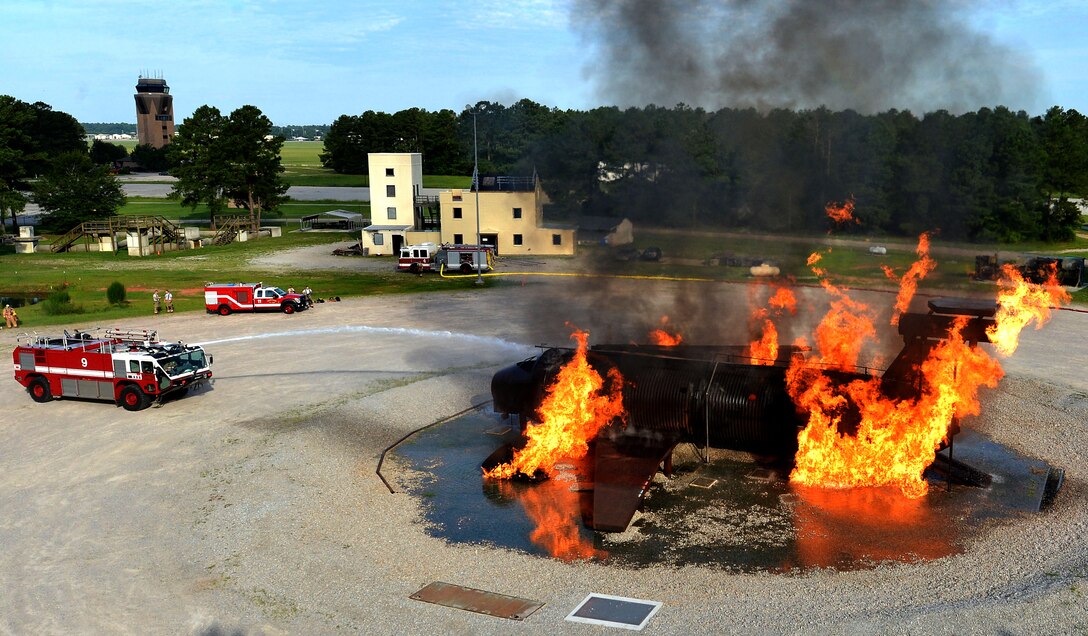 U.S. Airmen assigned to the 20th Civil Engineer Squadron fire department extinguish a mock C-130 Hercules aircraft fire during a live fire training scenario at Shaw Air Force Base, S.C., June 27, 2017. The training consisted of dousing fires on a newly-renovated mock C-130 and a larger structure fire trainer with movable walls. (U.S. Air Force photo by Senior Airman Christopher Maldonado)