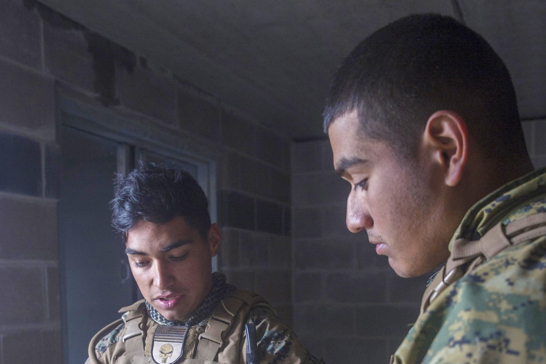 Marine Corps Cpl. Daniel A. Reyes, left, a joint fires observer with 3rd Brigade, 3rd Air Naval Gunfire Liaison Company, Force Headquarters Group, Marine Forces Reserve, points out target coordinates on his tablet to Marine Corps Lance Cpl. Romaldo Medina, a forward observer, at Camp Wainwright, Alberta, during exercise Maple Resolve 17, May 25, 2017. Marine Corps photo by Lance Cpl. Niles Lee