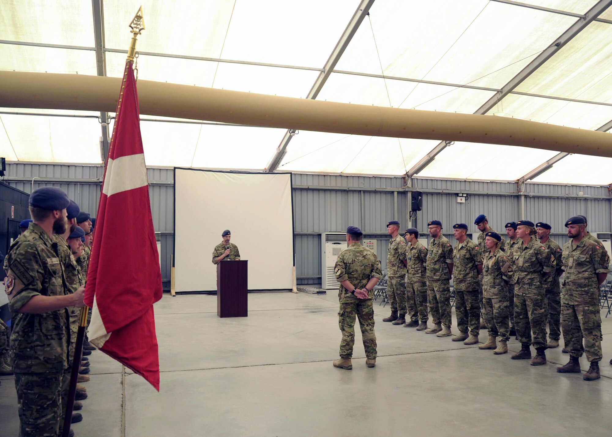 Royal Danish Air Force Lt. Col. John Pedersen, right, Team 7 Detachment commander, passes the Dannebrog, national flag of Denmark, to Royal Danish Air Force Lt. Col. Claus Pedersen, left, Team 8 Detachment commander, during a change of command ceremony June 29, 2017, at an undisclosed location in southwest Asia. As Coalition partners of the 380th Air Expeditionary Wing, both Team 7 and Team 8 members serve as integrated colleagues of the 727th Expeditionary Air Control Squadron. (U.S. Air Force Photo by Senior Airman Preston Webb)