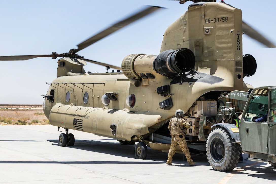 An Army Reserve crew chief supervises the loading of equipment onto a CH-47 Chinook helicopter in Helmand province, Afghanistan, June 21, 2017. Army photo by Capt. Brian Harris