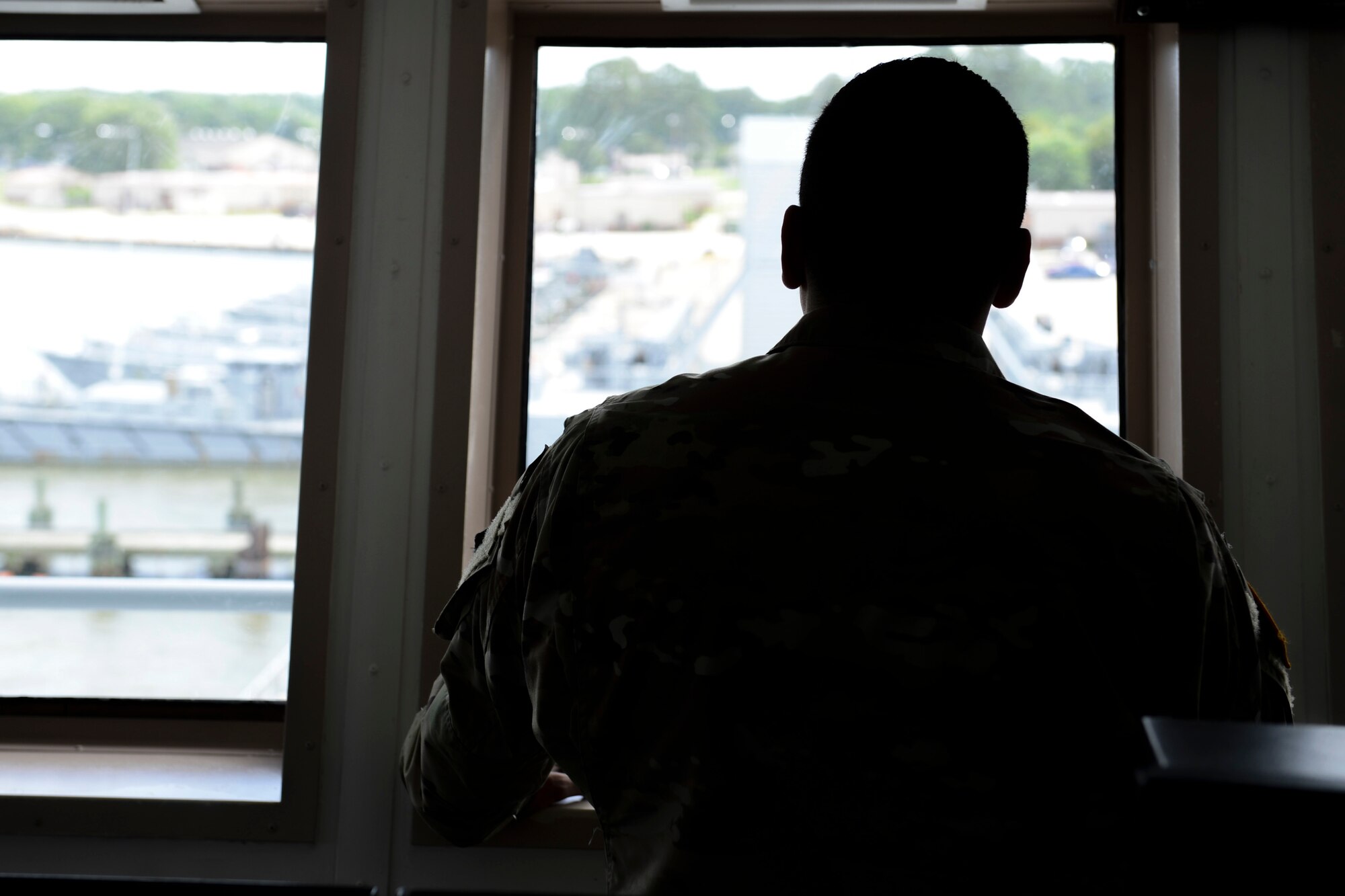 U.S. Army Spc. Miguel Ruelas Trejo, 335th Transportation Detachment, 7th Transportation Brigade (Expeditionary) quartermaster, looks out at Third Port while aboard the General Frank S. Besson-class logistics support vessel at Joint Base Langley-Eustis, Va., June 23, 2017. While entering or leaving a port, a quartermaster will steer the vessel with direction from the officer on duty. (U.S. Air Force photo/Airman 1st Class Kaylee Dubois)