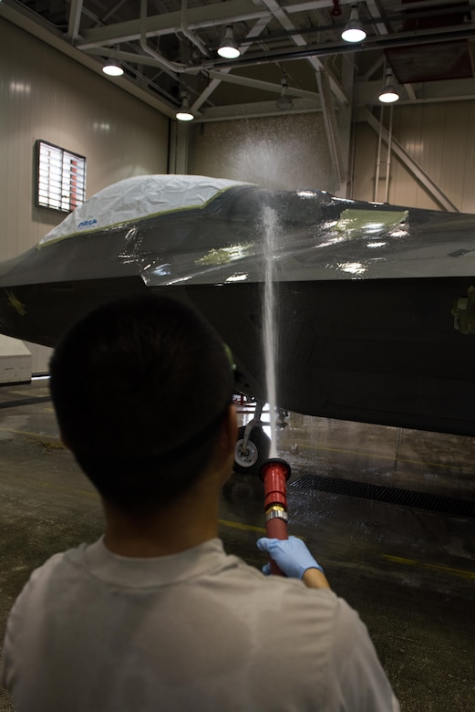U.S. Air Force Airman 1st Class Andy Luong, 1st Aircraft Maintenance Squadron, 94th Aircraft Maintenance Unit crew chief, washes a F-22 Raptor in the wash rack at Joint Base Langley-Eustis, Va., June 19, 2017. The F-22s are brought to the wash rack for scheduled inspections to ensure that the jets are in good condition and prepared for flight. (U.S. Air Force photo/Staff Sgt. J.D. Strong II )