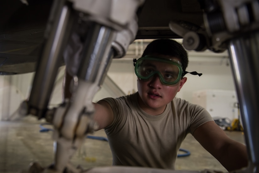 U.S. Air Force Airman 1st Class Joshua Aujero,1st Aircraft Maintenance Squadron, 27th Aircraft Maintenance Unit crew chief, cleans the front landing gear of a F-22 Raptor in the wash rack at Joint Base Langley-Eustis, Va., June 19, 2017. After cleaning the landing gears, lubricants are then applied to prevent metal on metal friction, ensuring the safety of the pilot. (U.S. Air Force photo/Staff Sgt. J.D. Strong II)