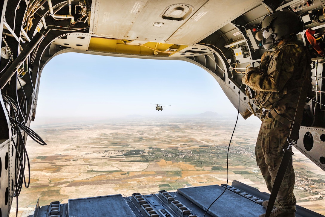 An Army Reserve pilot observes terrain below from the rear of a Ch-47 Chinook helicopter above Helmand province, Afghanistan, June 21, 2017. Army photo by Capt. Brian Harris 