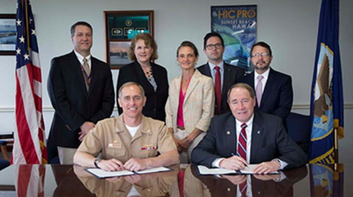 Capt. Michael R. Coughlin (seated, from left), commanding officer of the Naval Undersea Warfare Center Division, Newport, and Dr. David M. Dooley, president of the University of Rhode Island, sign an education partnership agreement on June 27.Looking on, are: David Grande (from left), NUWC Division Newport acting technical director; Dr. Theresa Baus, head of NUWC's Technical Partnership Office; Dr. Kimberly Cipolla, deputy chief technology officer; George Nickolopoulos, relationship manager, URI Business Engagement Center and Dr. Michael Katz, associate vice president of Intellectual Property and Economic Development, URI Research Foundation
